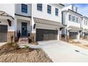 Elegant townhomes with white brick, dark metal roofs, and inviting entrances for modern living at 706 Dodd Ln # 157, Buford, GA 30518