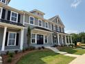 Inviting two-story townhome boasting a covered entrance, black shutters, and landscaped front yard at 1741 Prospect Way, Conyers, GA 30094