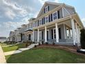 A row of well-maintained two-story townhomes featuring covered entrances, black shutters, and green lawns at 1741 Prospect Way, Conyers, GA 30094