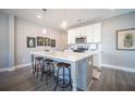 Well-lit kitchen featuring an island with barstool seating, white cabinets, and modern appliances at 1741 Prospect Way, Conyers, GA 30094