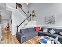 Inviting living space featuring hardwood floors, stairs to second floor and cozy sectional sofa at 2205 Hoskin Nw Ct # 9, Kennesaw, GA 30144