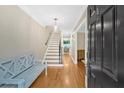 Inviting foyer with hardwood floors, a staircase, and a bench, creating a warm and welcoming atmosphere at 4 Mount Vernon Cir, Atlanta, GA 30338
