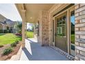 Charming covered front porch featuring brick columns and a stylish front door with sidelights at 741 Cams Crk, Mcdonough, GA 30253