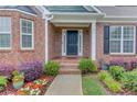 Inviting front porch with brick accents and colorful landscaping detail at 4235 Crestwood Bend Cir, Buford, GA 30518