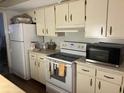 Kitchen with white cabinets, white countertops, and appliances including a stove, microwave, and refrigerator at 6354 Shannon Pkwy # 26C, Union City, GA 30291