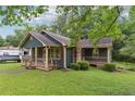 Cozy home with a covered front porch, accented by mature landscaping and an inviting, well-kept lawn at 160 Northside Ave, Dallas, GA 30157
