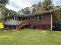 Rear view of the home showcasing an enclosed porch and access stairs to the backyard at 1791 Fairview Sw Dr, Austell, GA 30106