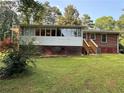 An enclosed porch and access stairs compliment the back exterior of the red brick home at 1791 Fairview Sw Dr, Austell, GA 30106