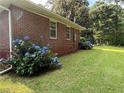 Lush green lawn with hydrangeas lining the red brick exterior of the home at 1791 Fairview Sw Dr, Austell, GA 30106