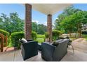 Inviting covered patio with comfortable seating, brick columns, and a serene view of the landscaped backyard at 580 River Valley Dr, Dacula, GA 30019
