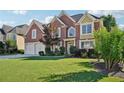 Charming brick home featuring a well-manicured lawn and a two-car garage, set under a bright, partly cloudy sky at 2909 Everson Ridge Ct, Snellville, GA 30039
