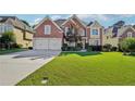 Charming brick home featuring a well-manicured lawn and a two-car garage, set under a bright, partly cloudy sky at 2909 Everson Ridge Ct, Snellville, GA 30039