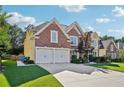 Charming brick home featuring a well-manicured lawn and a two-car garage, set under a bright, partly cloudy sky at 2909 Everson Ridge Ct, Snellville, GA 30039