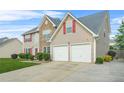 Two-story home with stone facade and a two-car garage, complemented by a lush green lawn at 60 Heaton Dr, Covington, GA 30016