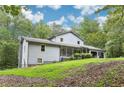 A charming home with a manicured lawn, lush green trees, and a welcoming facade at 8464 Pleasant Hill Rd, Lithonia, GA 30058