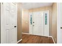 A welcoming foyer featuring gleaming hardwood floors and a classic white front door with sidelights at 8464 Pleasant Hill Rd, Lithonia, GA 30058