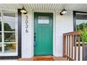 Home's inviting green front door features updated sconces, hardware, and a glass window at 3036 Horse Shoe Se Dr, Atlanta, GA 30316