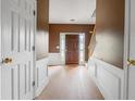Foyer with view of wood front door and neutral wall paint, hard surface floors, and staircase at 10795 Glenbarr Dr, Johns Creek, GA 30097