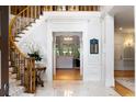 Elegant foyer featuring a curved staircase with iron railings and marble floors and views to formal living room at 3639 Paper Mill Se Rd, Marietta, GA 30067