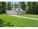 A beautiful two-story home showcases lush green lawn, long driveway and mature trees at 3729 Meadow Glen Cir, Ellenwood, GA 30294
