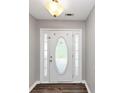 Bright entrance with a decorative glass door and dark laminate flooring at 5514 E Stoneway Ct, Villa Rica, GA 30180