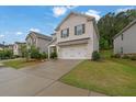 Two-story home featuring a brick facade, two-car garage and driveway, and a well-maintained front yard at 1998 Nuthatch Dr, Hoschton, GA 30548