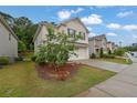 View of a two-story home, featuring a brick facade, two-car garage, and landscaped front yard at 1998 Nuthatch Dr, Hoschton, GA 30548