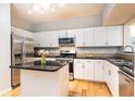 Modern kitchen featuring stainless steel appliances, an island, granite countertops, and white cabinetry at 220 Renaissance Ne Pkwy # 1105, Atlanta, GA 30308