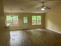 Bright living room with hardwood floors, ceiling fan, and natural light from windows overlooking the backyard deck at 2850 Cedar Trace Dr, Ellenwood, GA 30294
