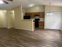 Open concept living space featuring hardwood floors flowing into the kitchen with black appliances and vaulted ceilings at 2850 Cedar Trace Dr, Ellenwood, GA 30294