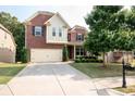 Two-story brick home with attached garage and landscaped front yard at 3020 Whitfield Ave, Cumming, GA 30040