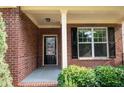 Close up of front porch with brick facade, black door and window shutters at 3020 Whitfield Ave, Cumming, GA 30040