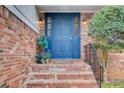 A close up of a blue front door featuring brickwork, iron railing, and greenery, enhancing its appeal at 2270 Old Concord Se Dr, Covington, GA 30016
