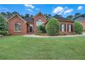 Charming brick home featuring a well-kept lawn and professionally designed landscaping for an inviting exterior at 8108 Greens Mill Way, Loganville, GA 30052