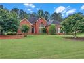 Well-maintained brick home with lush green lawn and established landscaping, creating a welcoming curb appeal at 8108 Greens Mill Way, Loganville, GA 30052