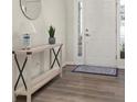 Well-lit entryway featuring a decorative table, stylish mirror and light colored wood flooring at 4470 Madison Hall Dr, Cumming, GA 30028