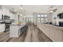 Open-concept living space featuring a kitchen island, hardwood floors, and ample natural light at 4470 Madison Hall Dr, Cumming, GA 30028