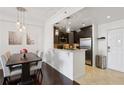 Bright dining room with dark wood floors and a view into the modern kitchen with stainless appliances at 1101 Juniper Ne St # 1012, Atlanta, GA 30309