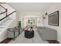 Bright, open-concept living room boasts hardwood floors and stylish gray furnishings at 153 Towey Trl, Woodstock, GA 30188