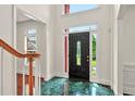 Bright foyer features gleaming tile floors, a decorative door, and views to a wood staircase at 240 Flowers Cove Ln, Lilburn, GA 30047