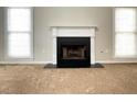 Cozy living room featuring a classic white fireplace and large windows at 690 Kimball Parc Way, Alpharetta, GA 30022