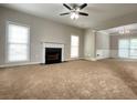 Bright living room with neutral paint, carpet, ceiling fan, and a cozy fireplace at 690 Kimball Parc Way, Alpharetta, GA 30022