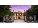 Elegant two-story home showcasing a gated entrance, lush greenery, and beautiful sunset sky at 1430 N Harris Rdg, Atlanta, GA 30327