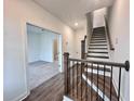 Bright entryway with hardwood floors, staircase, and an open view of a carpeted living area and adjacent bathroom at 532 Healy Dr # 61, Cumming, GA 30040