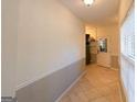 Neutral hallway featuring tile floors, decorative trim, and bright natural light at 8245 Mill Run Trl, Whitesburg, GA 30185