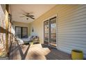 Inviting covered porch featuring comfortable seating, ceiling fan, and natural light at 8245 Mill Run Trl, Whitesburg, GA 30185