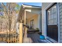Covered porch showcasing wood flooring and railing that leads to the front door at 8245 Mill Run Trl, Whitesburg, GA 30185