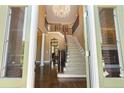 Grand foyer showcasing hardwood floors, a stunning staircase, and a elegant chandelier at 3410 Kates Way, Duluth, GA 30097