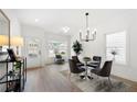 Airy dining area with modern lighting, wood floors, and ample natural light from multiple windows at 150 Chandler Trce, Covington, GA 30016