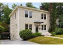Beautiful two-story home with a brick exterior, lush greenery, and a driveway leading to the side entrance at 851 Courtenay Ne Dr, Atlanta, GA 30306